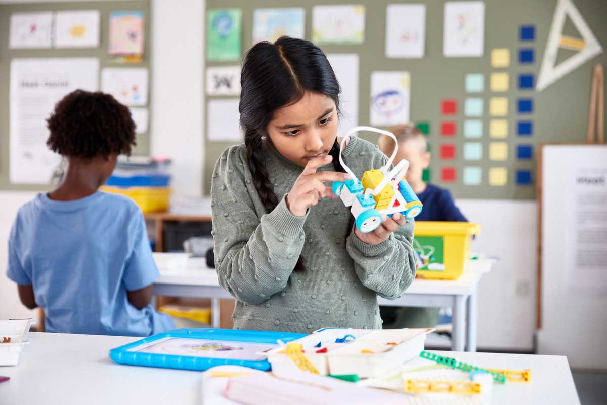 Young girl working with LEGO S.T.E.A.M. educational toy.